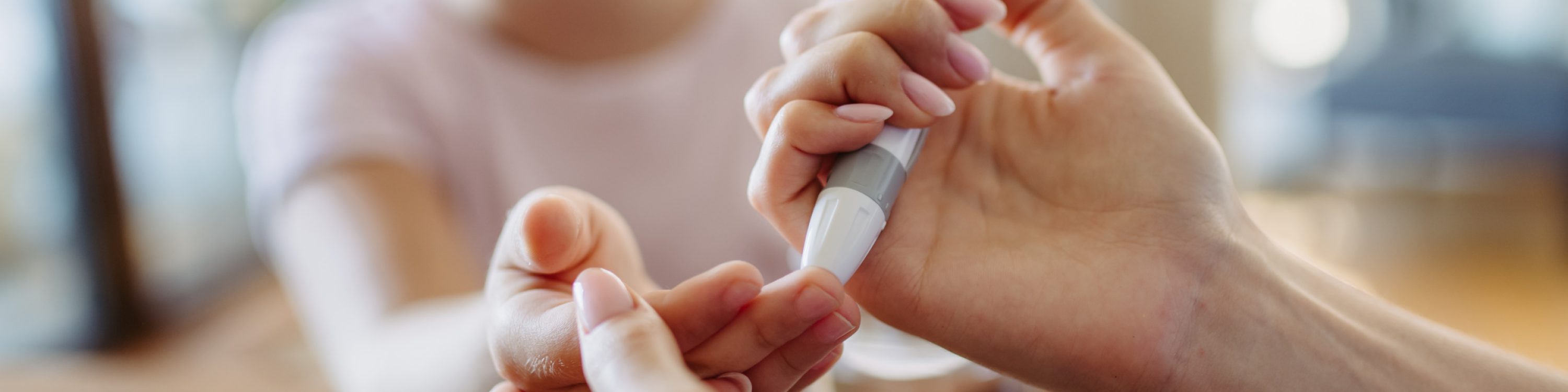 Close up of mother checking girl’s blood glucose level using fingerstick glucose meter. Endocrinologist waiting for results from blood test. Close up of mother checking girl's blood glucose level using a fingerstick glucose meter. Endocrinologist waiting for results from blood test.